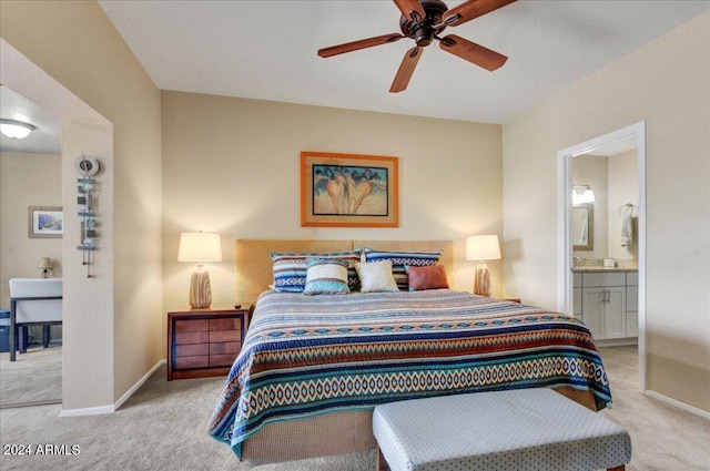 carpeted bedroom with ensuite bathroom and ceiling fan