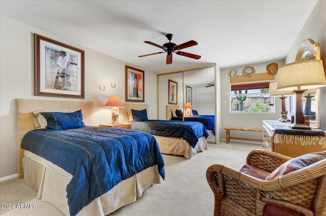 bedroom with a closet, light colored carpet, and ceiling fan