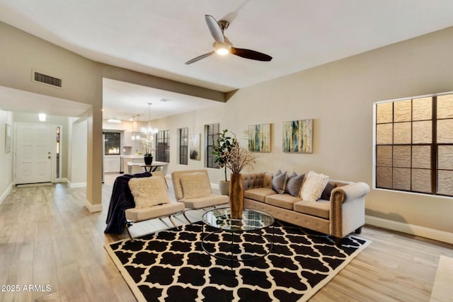 2110 W Navarro Ave, Mesa, AZ 85202 - living area with light wood finished floors, ceiling fan, a chandelier, and plenty of natural light