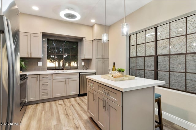 2110 W Navarro Ave, Mesa, AZ 85202 - kitchen featuring appliances with stainless steel finishes, decorative backsplash, light wood-style floors, a breakfast bar, and light countertops