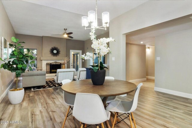 2110 W Navarro Ave, Mesa, AZ 85202 - dining area with light wood finished floors, ceiling fan, a stone fireplace, and a chandelier