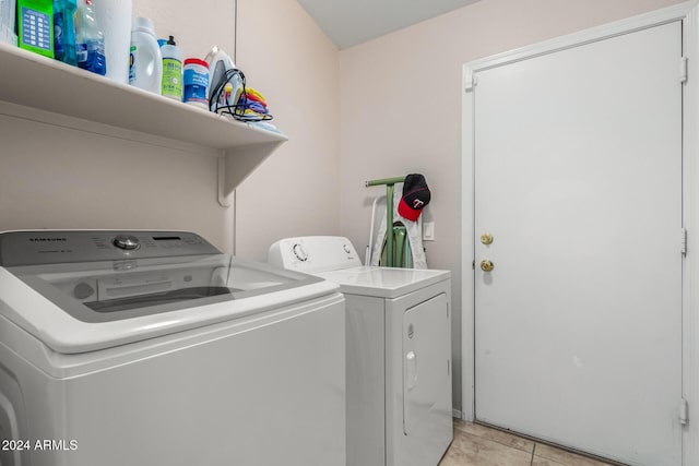 clothes washing area with washing machine and dryer and light tile patterned floors