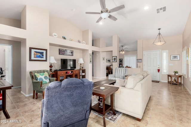 tiled living room featuring ceiling fan and high vaulted ceiling