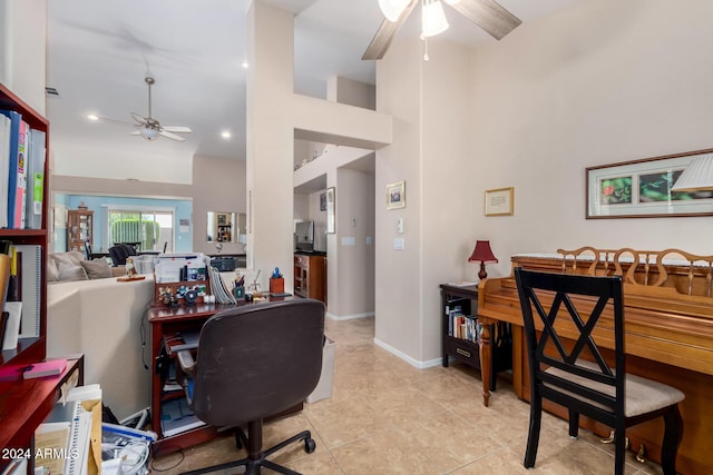 office space featuring ceiling fan, light tile patterned flooring, and a towering ceiling