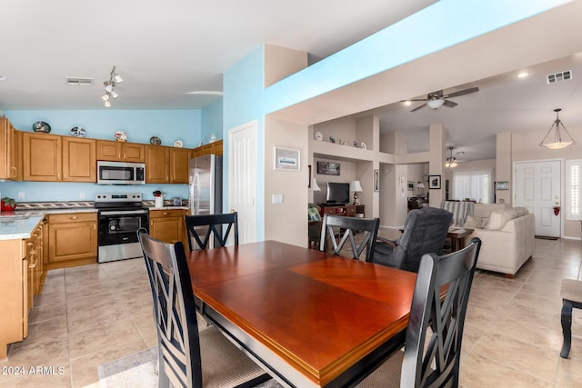 tiled dining room with ceiling fan and lofted ceiling