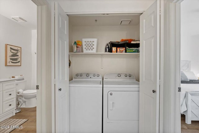 washroom with light hardwood / wood-style floors and washing machine and clothes dryer