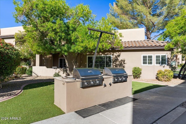 view of front of property featuring area for grilling and a front lawn