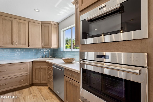 14802 N 3rd Ave, Phoenix, AZ 85023 - kitchen featuring appliances with stainless steel finishes, a sink, light countertops, light wood-style flooring, and backsplash