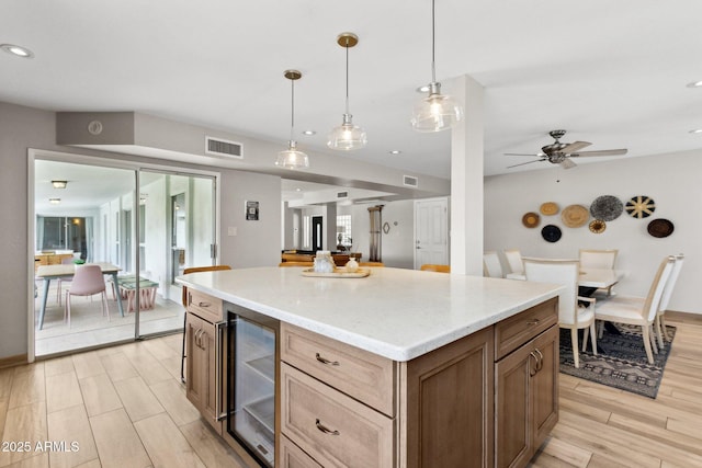 14802 N 3rd Ave, Phoenix, AZ 85023 - kitchen featuring visible vents, wine cooler, light wood-style floors, a center island, and hanging light fixtures