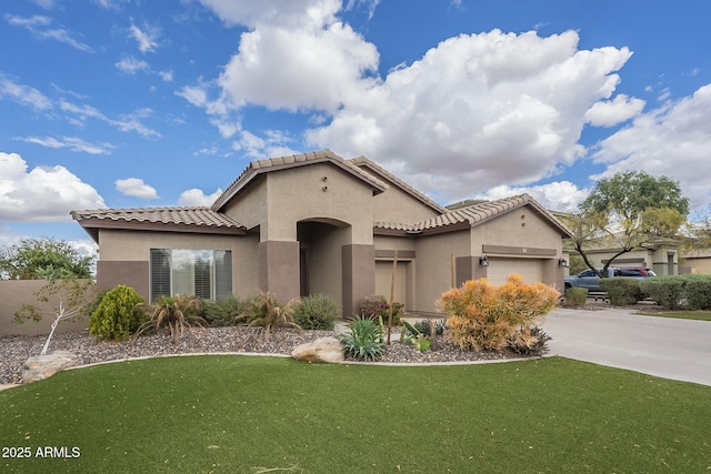 mediterranean / spanish home with a front yard, a garage, driveway, and stucco siding