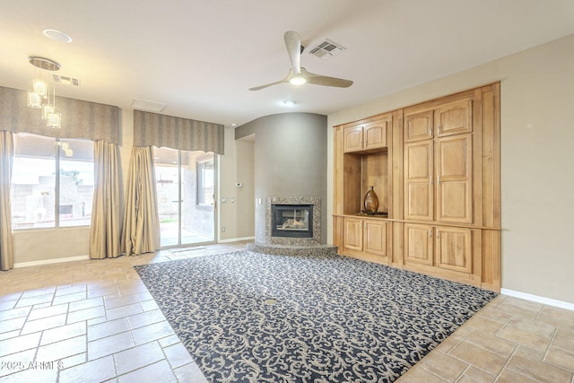 living area with a ceiling fan, a fireplace, visible vents, and baseboards