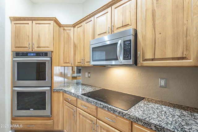 kitchen featuring tile counters, a textured wall, and stainless steel appliances