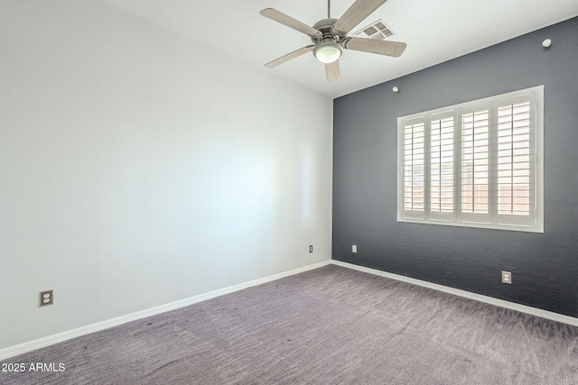 carpeted spare room featuring visible vents, ceiling fan, and baseboards