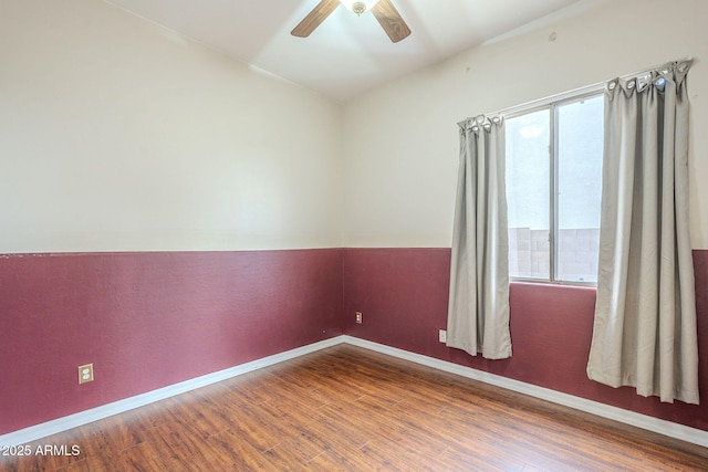 unfurnished room with baseboards, wood finished floors, and a ceiling fan