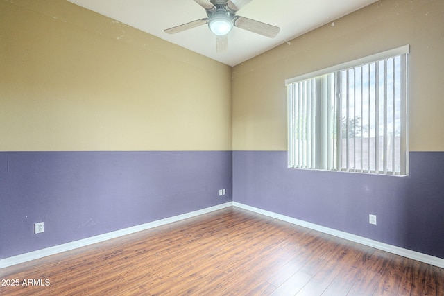 spare room with wood finished floors, baseboards, and ceiling fan