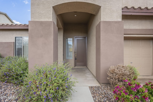 property entrance featuring stucco siding and a tiled roof