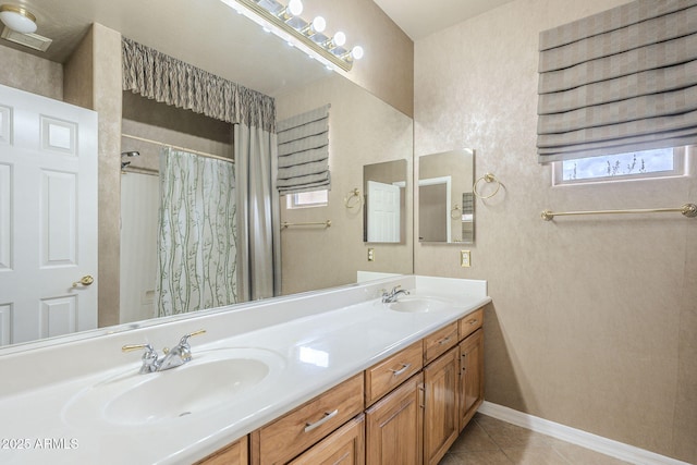 full bathroom with tile patterned floors, double vanity, baseboards, and a sink