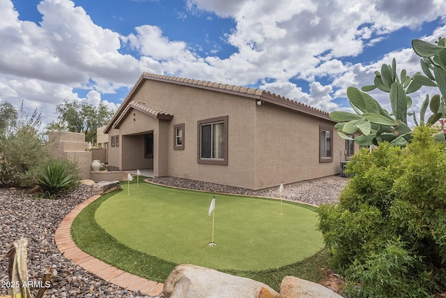 back of house featuring stucco siding, fence, cooling unit, and a tile roof