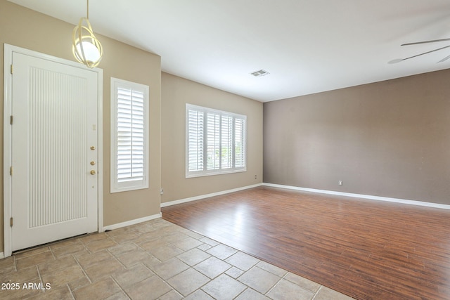 foyer featuring a ceiling fan, wood finished floors, visible vents, and baseboards