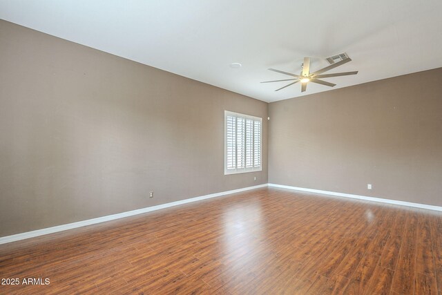 spare room with visible vents, ceiling fan, baseboards, and wood finished floors