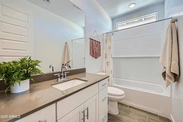 full bath featuring visible vents, wood finish floors, toilet, shower / tub combo, and vanity