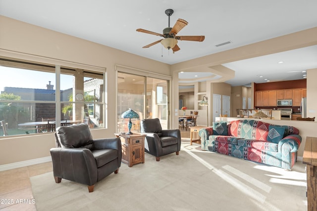 tiled living room with ceiling fan