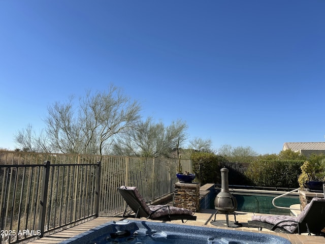 view of swimming pool with a hot tub