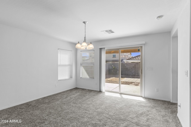 unfurnished room featuring carpet floors and a notable chandelier