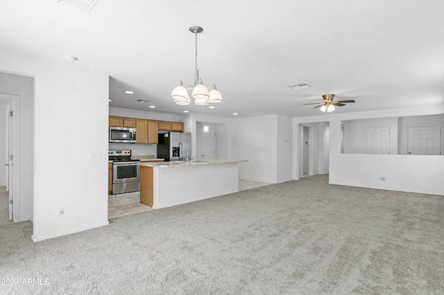 kitchen with hanging light fixtures, a kitchen island, stainless steel appliances, and light colored carpet