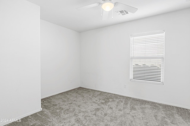 spare room featuring light carpet and ceiling fan