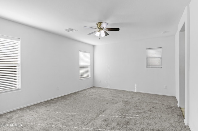 carpeted spare room featuring ceiling fan