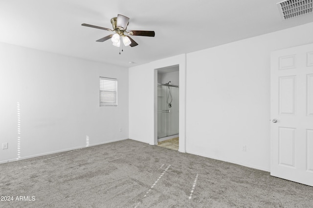 unfurnished bedroom featuring ceiling fan, a spacious closet, light carpet, and a closet