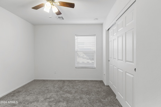 carpeted spare room with ceiling fan