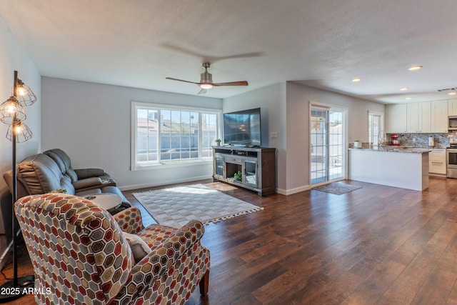 living area with plenty of natural light, baseboards, dark wood-style flooring, and recessed lighting