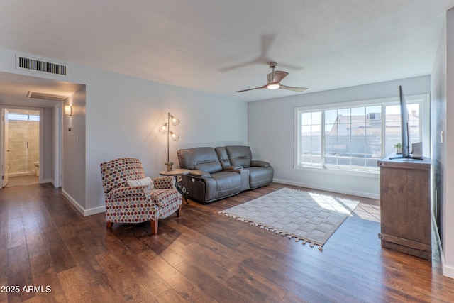 living room with a ceiling fan, baseboards, visible vents, and dark wood-type flooring