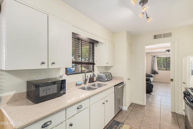 kitchen with range, white cabinets, sink, dishwasher, and light tile patterned floors