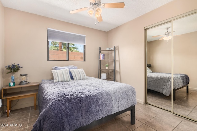 tiled bedroom featuring a textured ceiling, ceiling fan, and a closet