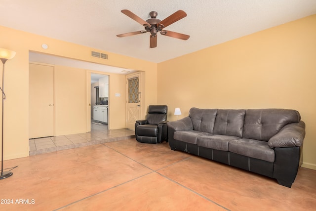 tiled living room featuring a textured ceiling and ceiling fan