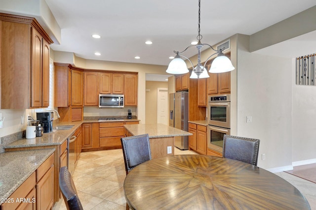 kitchen featuring brown cabinets, light stone countertops, stainless steel appliances, a sink, and recessed lighting