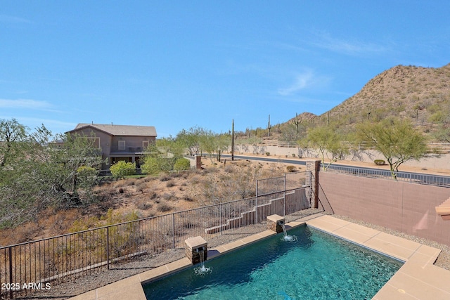 view of swimming pool with a fenced backyard, a mountain view, and a fenced in pool