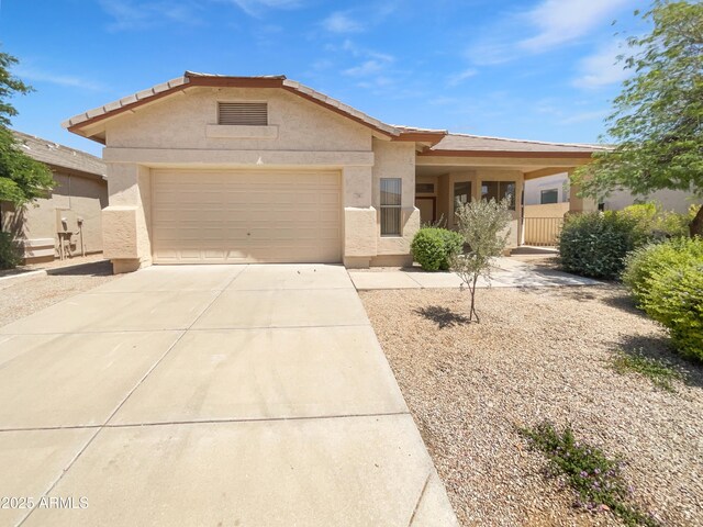 view of front of home with driveway, a garage, stucco siding, and a tiled roof