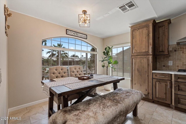 dining space featuring visible vents, an inviting chandelier, and baseboards