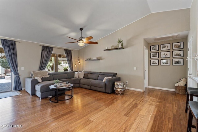 living area with vaulted ceiling, baseboards, light wood-type flooring, and ceiling fan