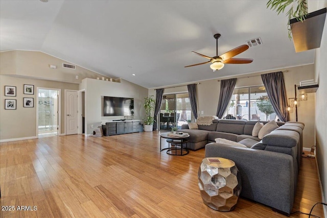 living room featuring visible vents, lofted ceiling, and light wood-style floors