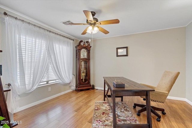 office space with visible vents, baseboards, light wood-type flooring, and ceiling fan