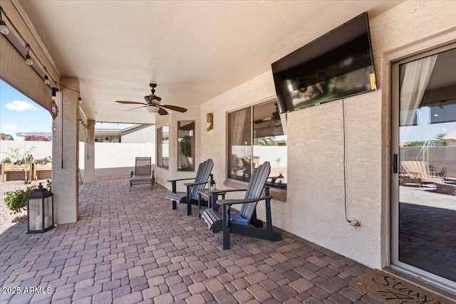 view of patio featuring a ceiling fan and fence