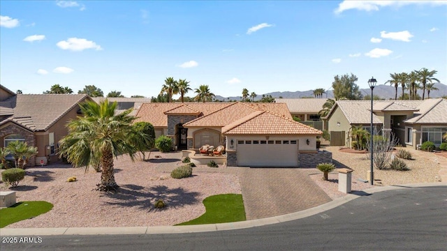 view of front facade featuring a tile roof, stucco siding, decorative driveway, a garage, and stone siding