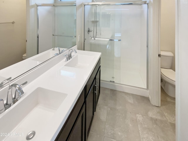 bathroom with a shower with door, vanity, and toilet