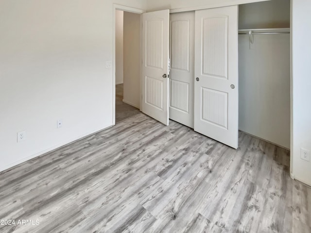 unfurnished bedroom with light hardwood / wood-style floors and a closet