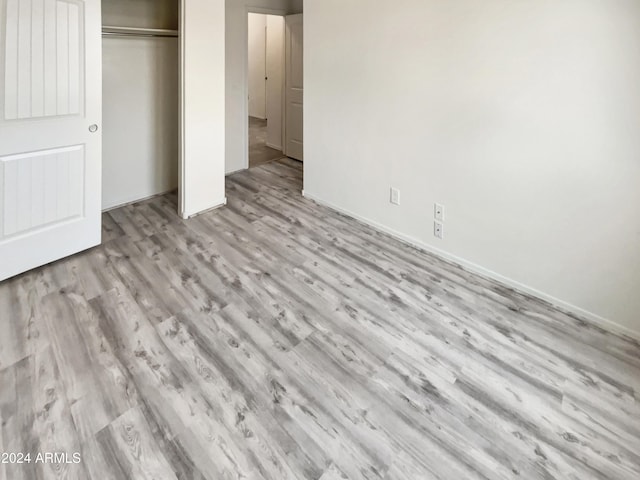 unfurnished bedroom featuring light wood-type flooring and a closet